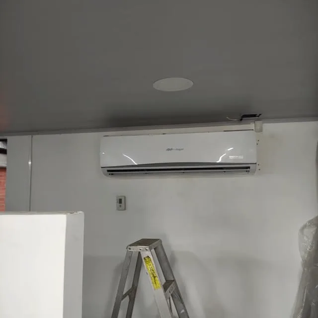 Split recién instalado en un espacio blanco, con la escalera todavía al lado