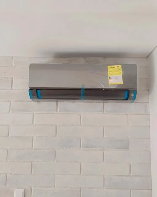 Equipo nuevo todavía con su protección, sobre una pared de ladrillo blanco
